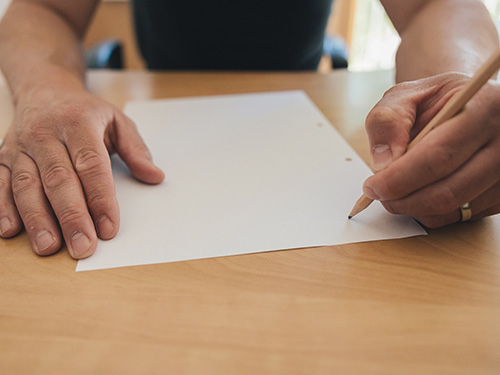 A person filling out a paper.