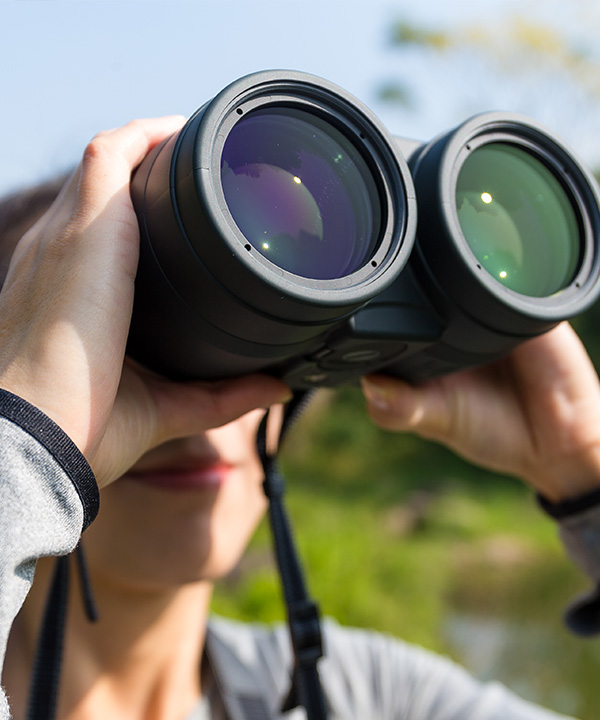 A woman using binoculars.