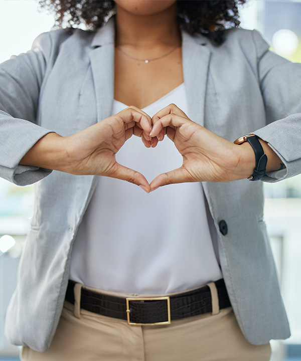 A woman with her hands in the shape of a heart.